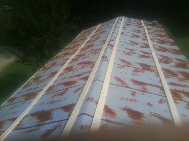 Rusted metal roof panels with new wood purlins before replacement — Storm Damage Roof Repair in Duncansville by Roofing Brothers