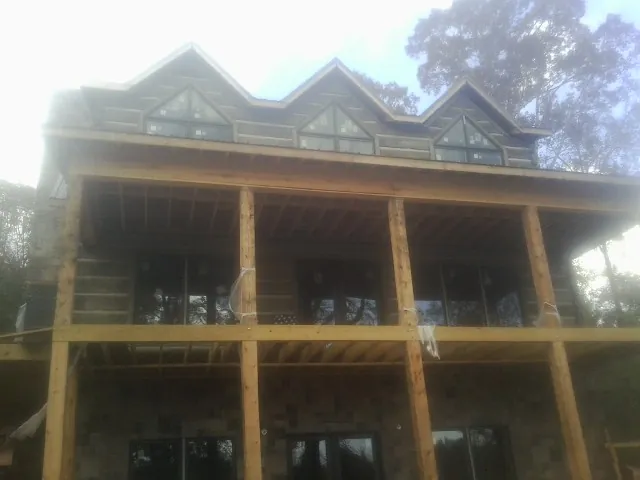Dormers and porch framing on a large log home under construction — Roof Coating work by our crew in Duncansville
