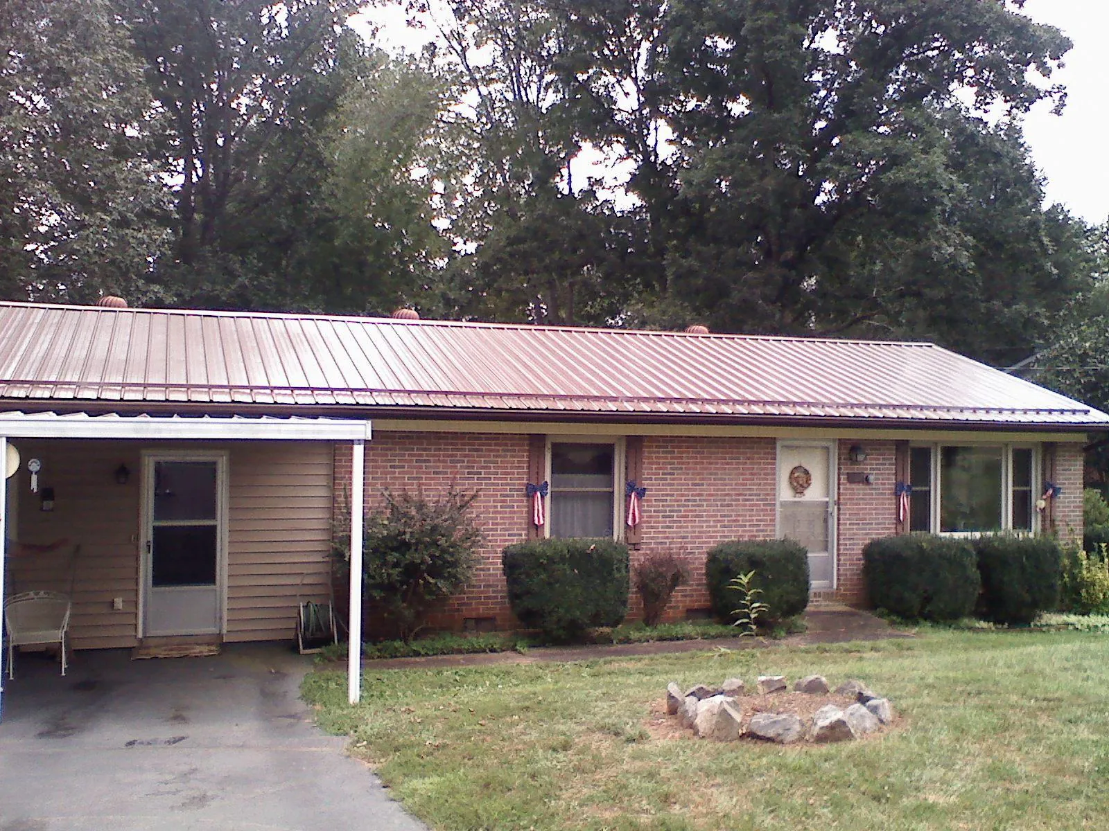 Bronze metal roof and carport on a brick ranch home — Roof Repair work by our crew in Duncansville